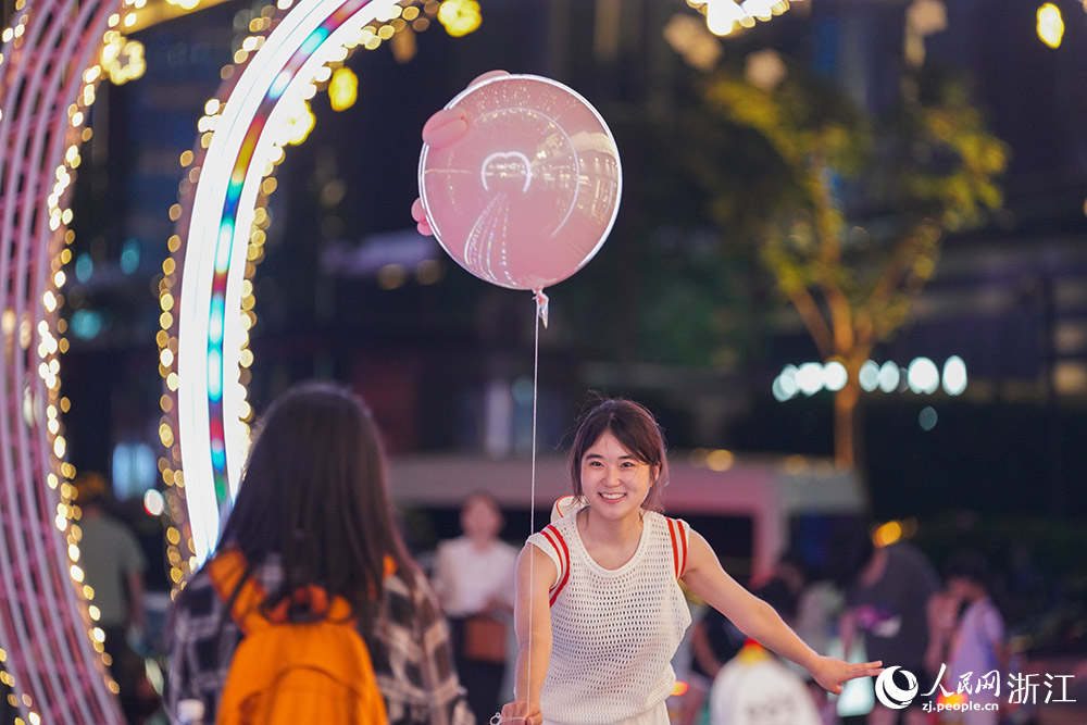 5月25日，杭州武林夜市燈光秀吸引游客駐足，拍照打卡留念。人民網(wǎng) 章勇濤攝