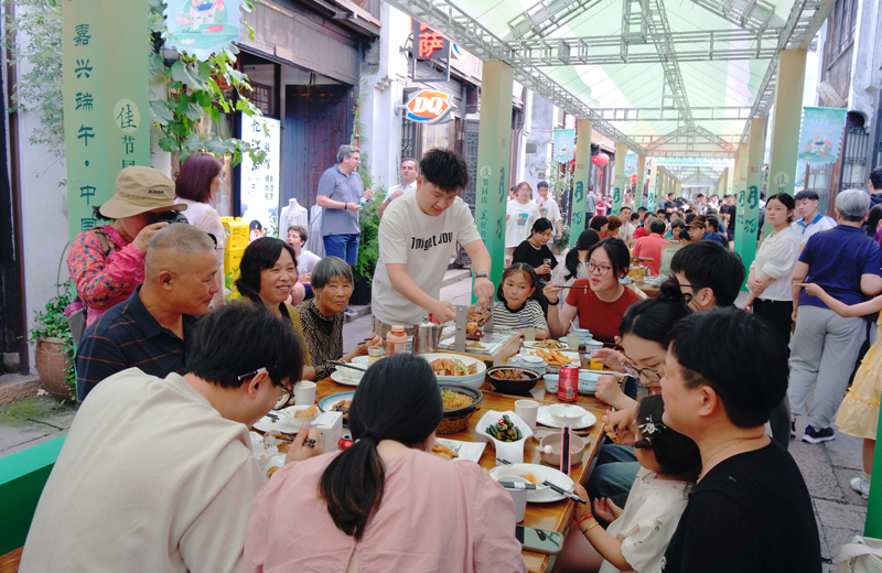 月河歷史街區(qū)內(nèi)，市民游客正在參與五黃長街宴活動。程欣攝